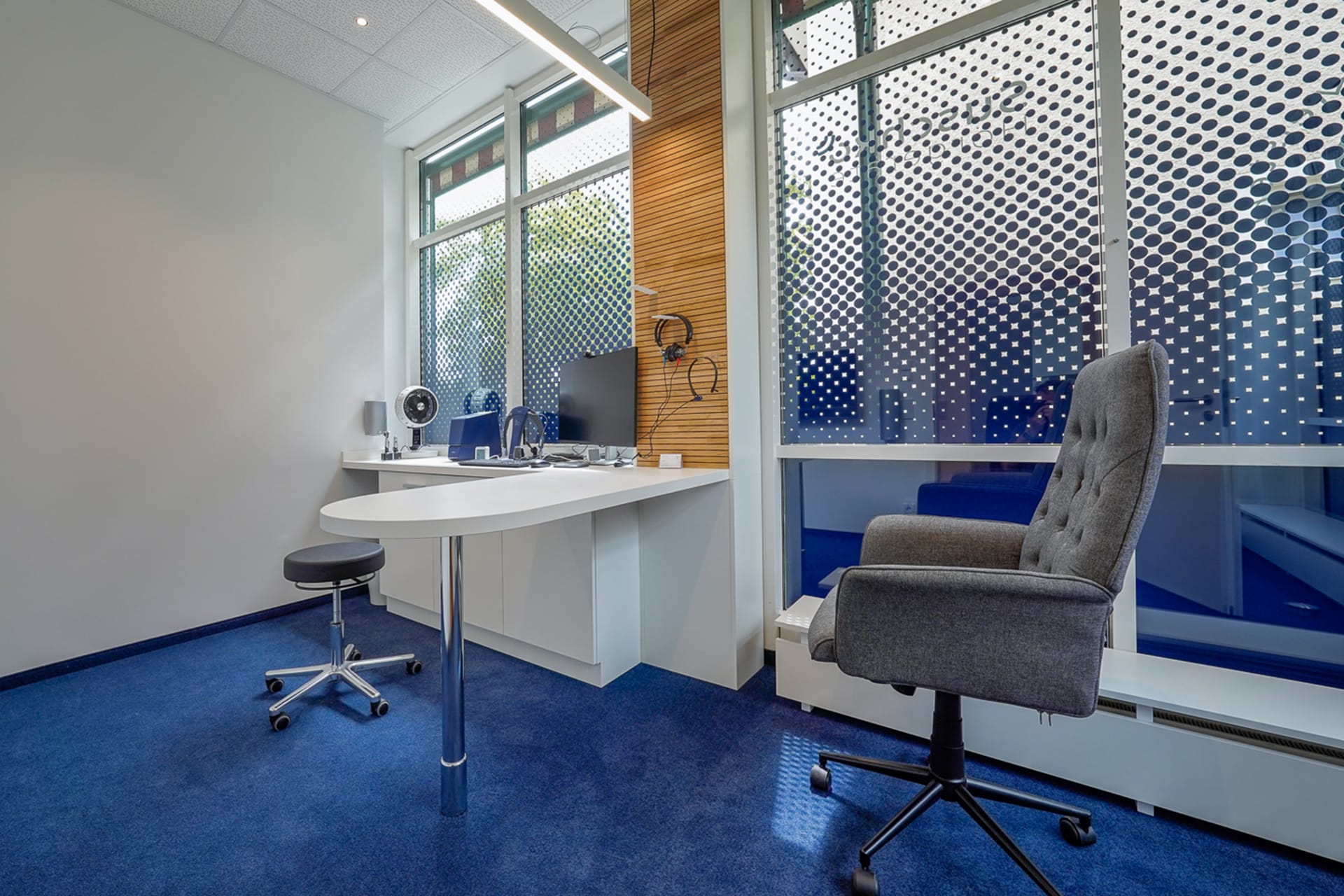 Professioneller Hörtest-Arbeitsplatz mit moderner Ausstattung und blauem Teppichboden